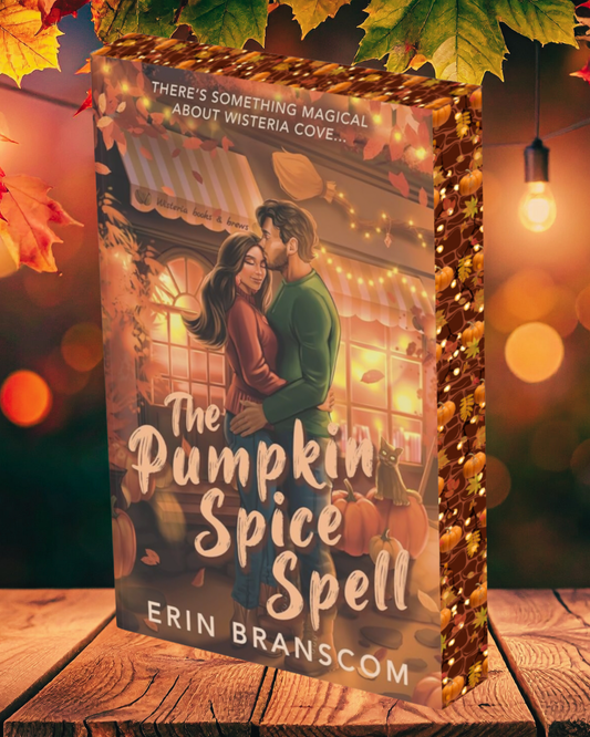 Book titled 'The Pumpkin Spice Spell' by Erin Branscom with a couple embracing in front of a lit building, surrounded by autumn leaves and lights.